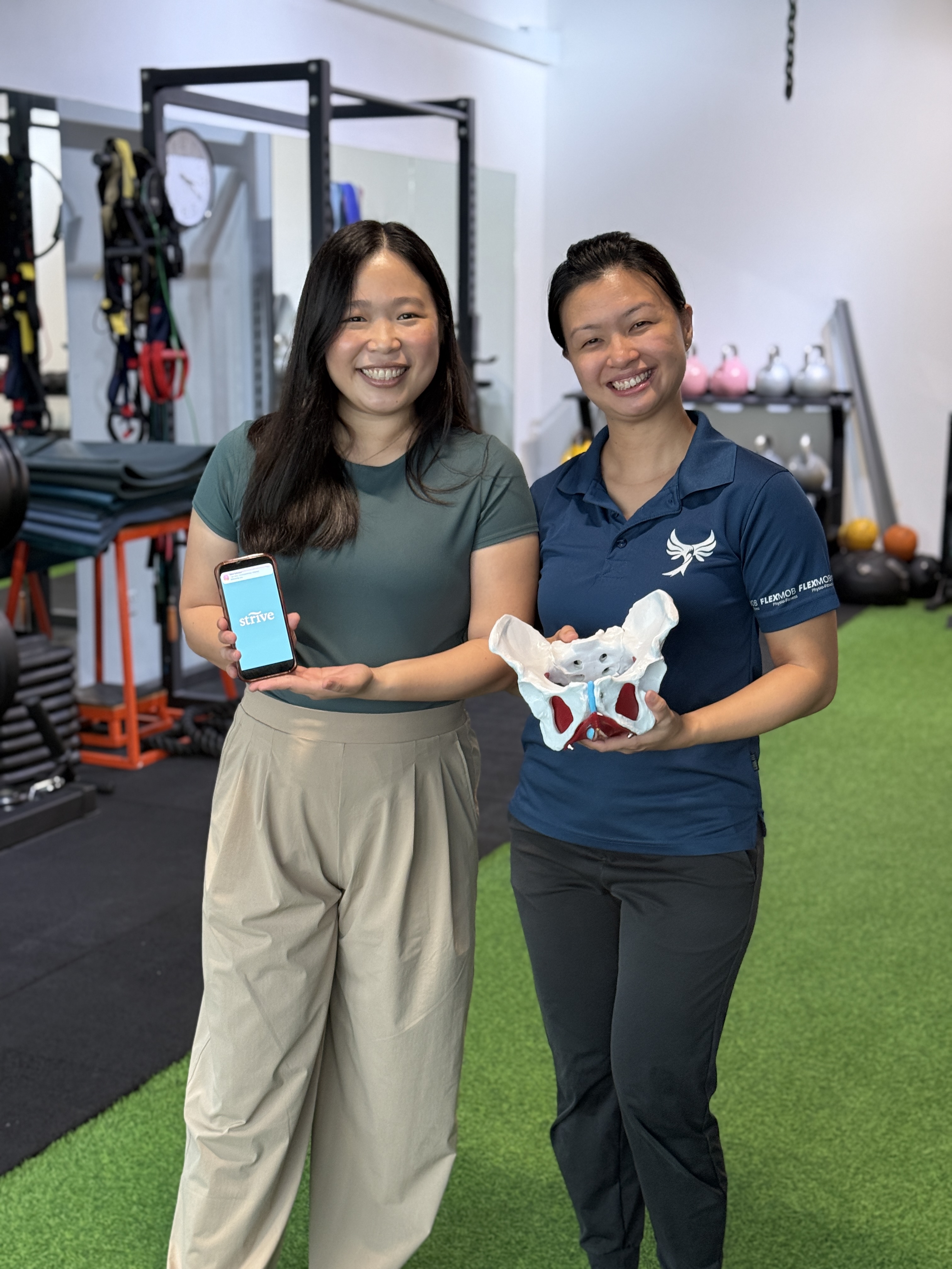 Lily holding the Strive app beside Lavinia holding a pelvic model